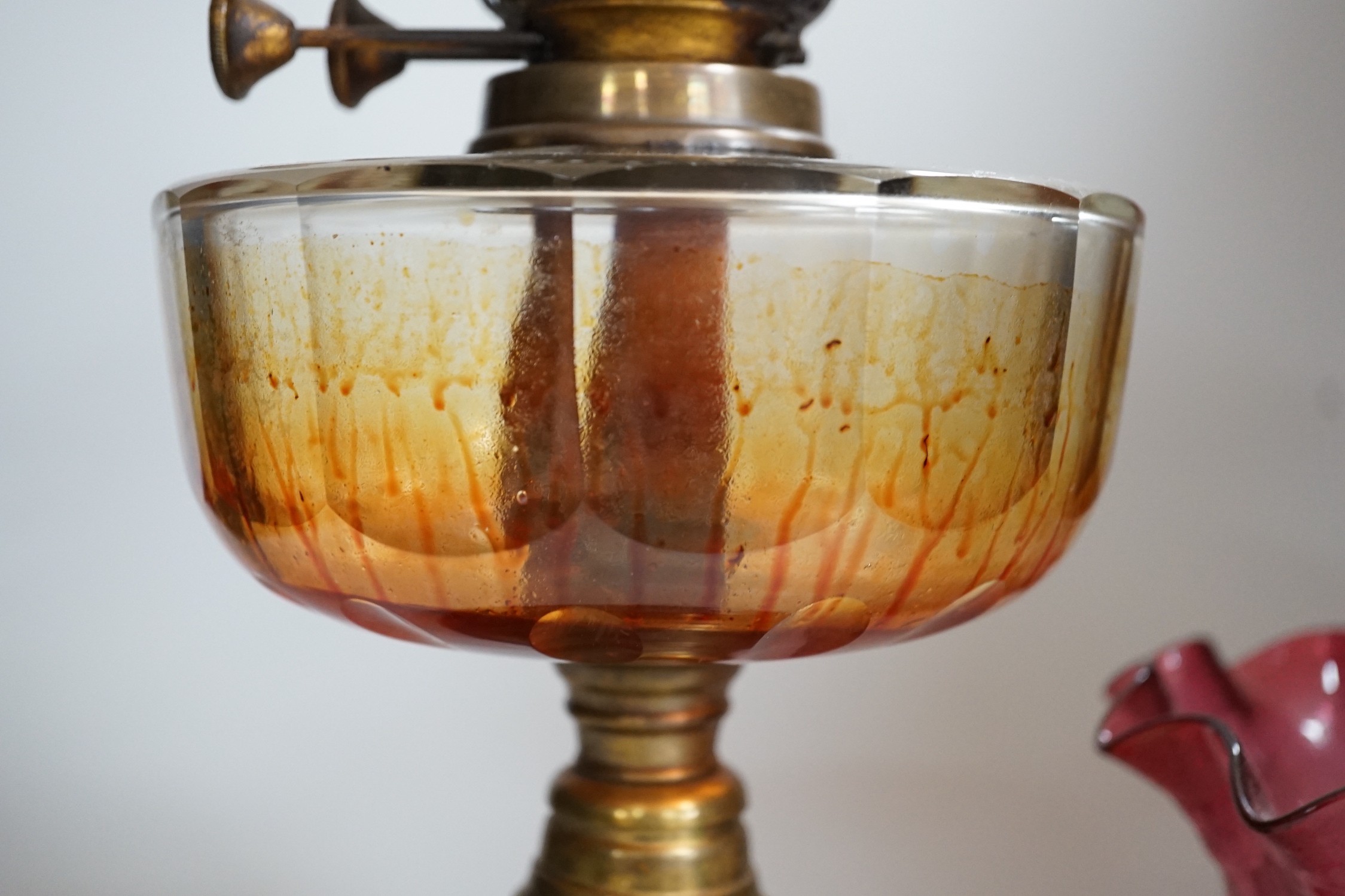 A Victorian brass and cranberry glass oil lamp